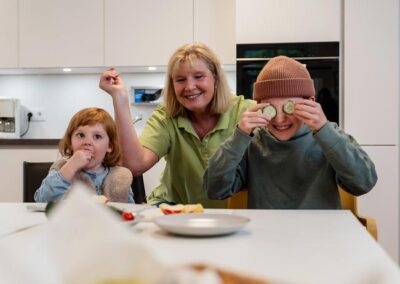 Kinder mit Betreuerin in der Küche beim Essen