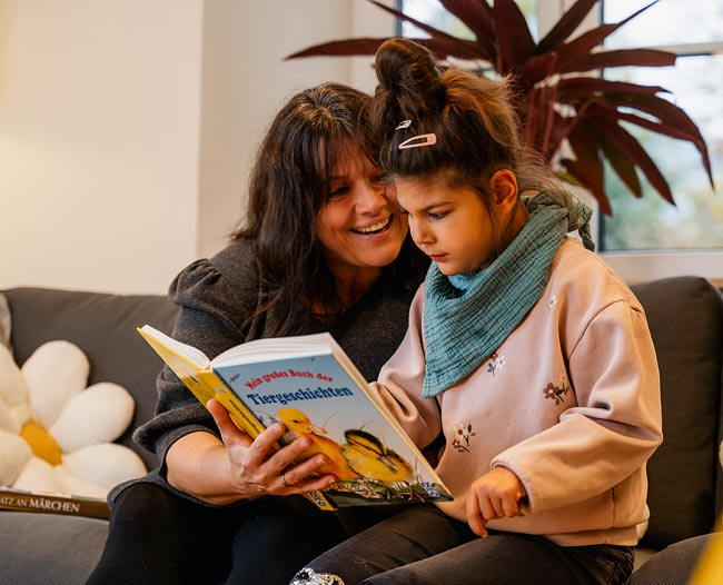 Pflegekind bekommt aus einem Buch vorgelesen
